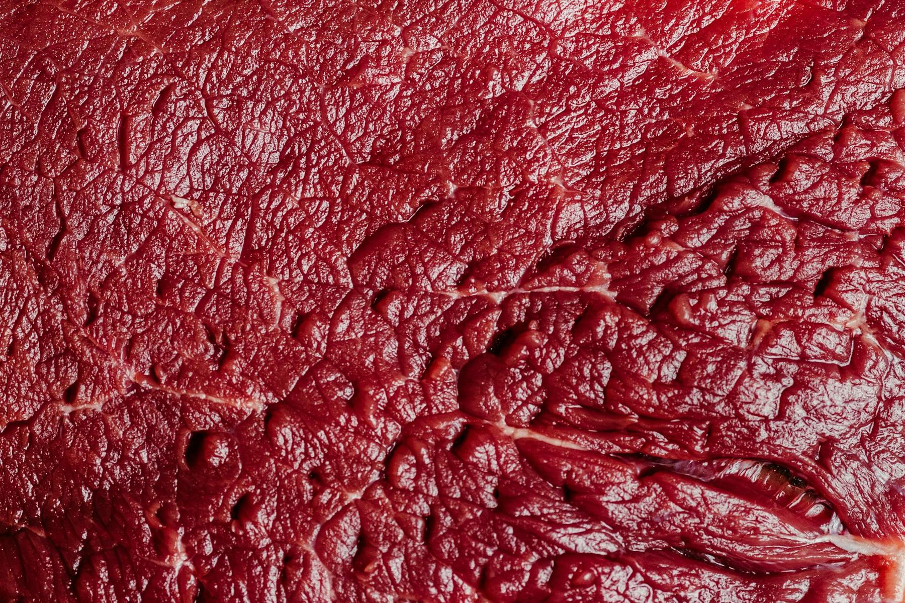 Gros plan d'une pièce de boeuf cru rouge sélectionnée à l'étal de la Maison Bréval